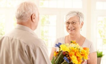Elderly Man Giving Elderly Woman Flowers